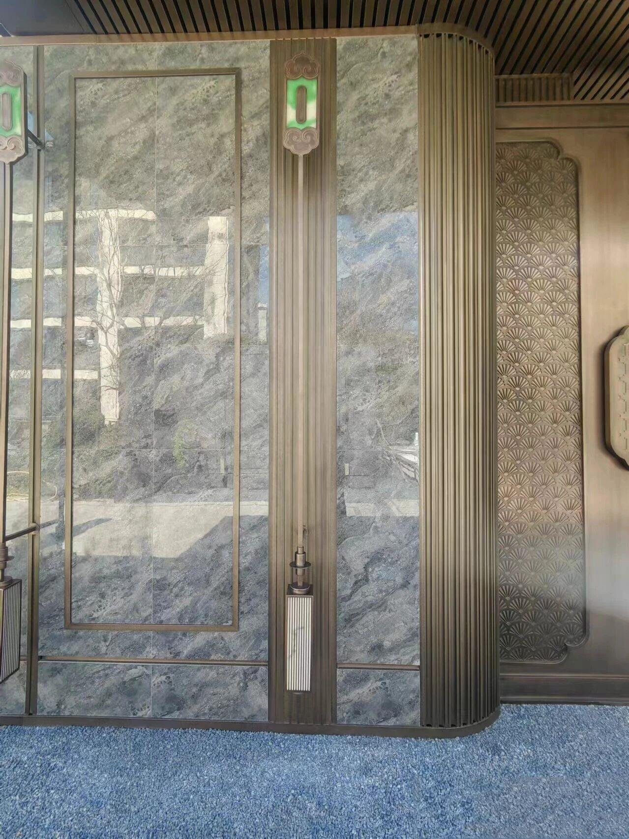 Bronze PVD fluted metal trim inlaid in marble wall panels for high-end architectural interiors.