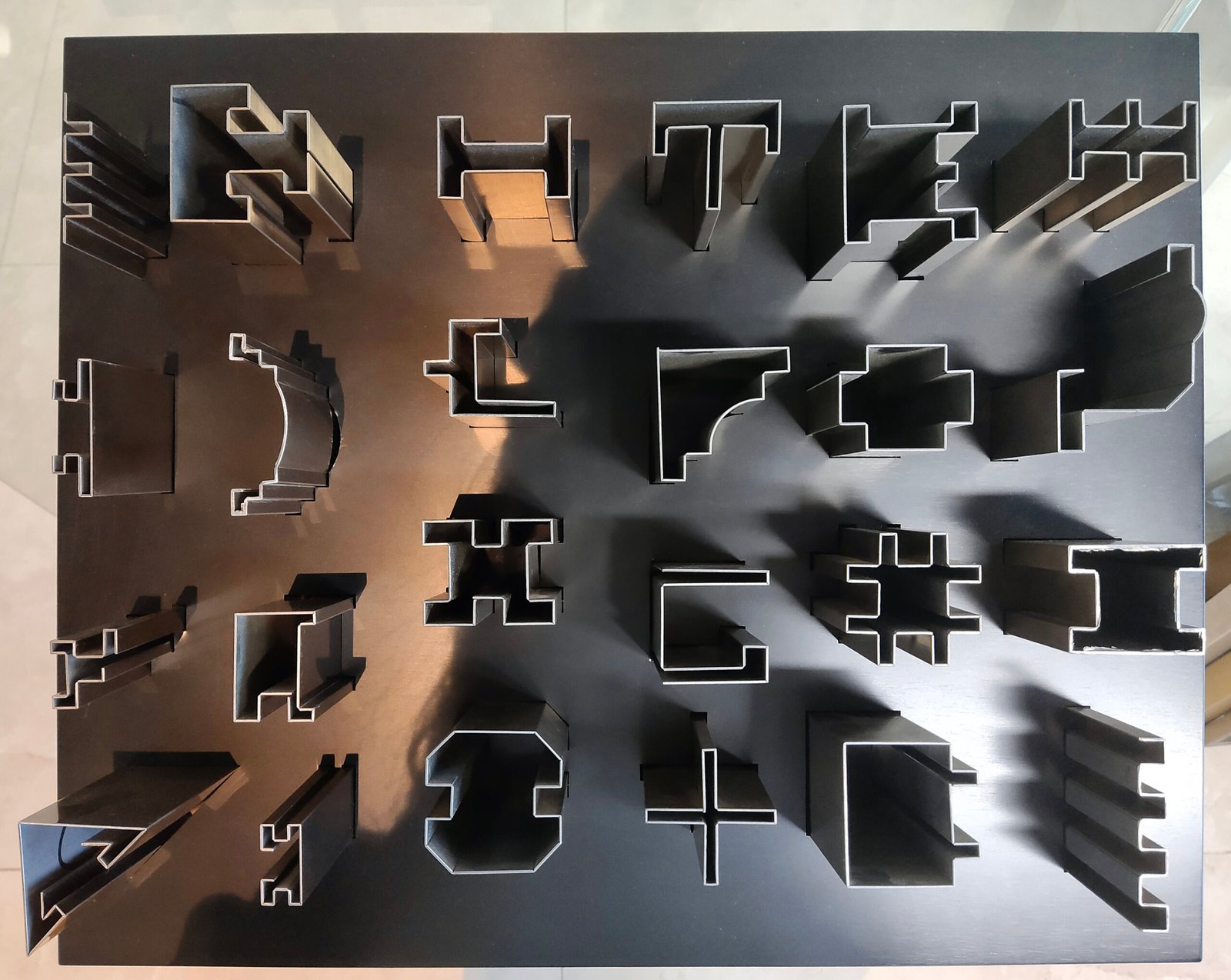 Multiple custom architectural stainless steel profile sections with T-shape and U-shape designs