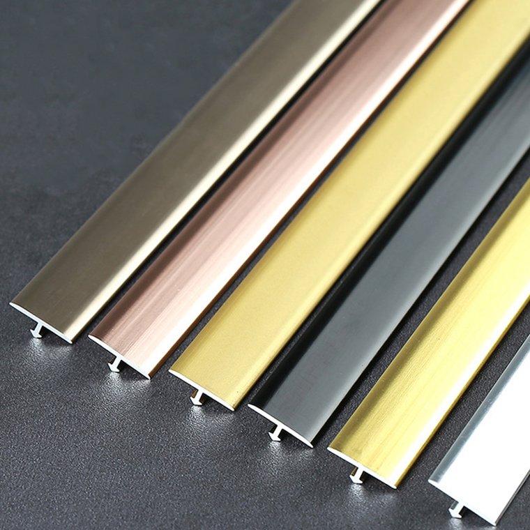 Collection of brushed metal T-bar transition profiles in different colors for wall and floor joints