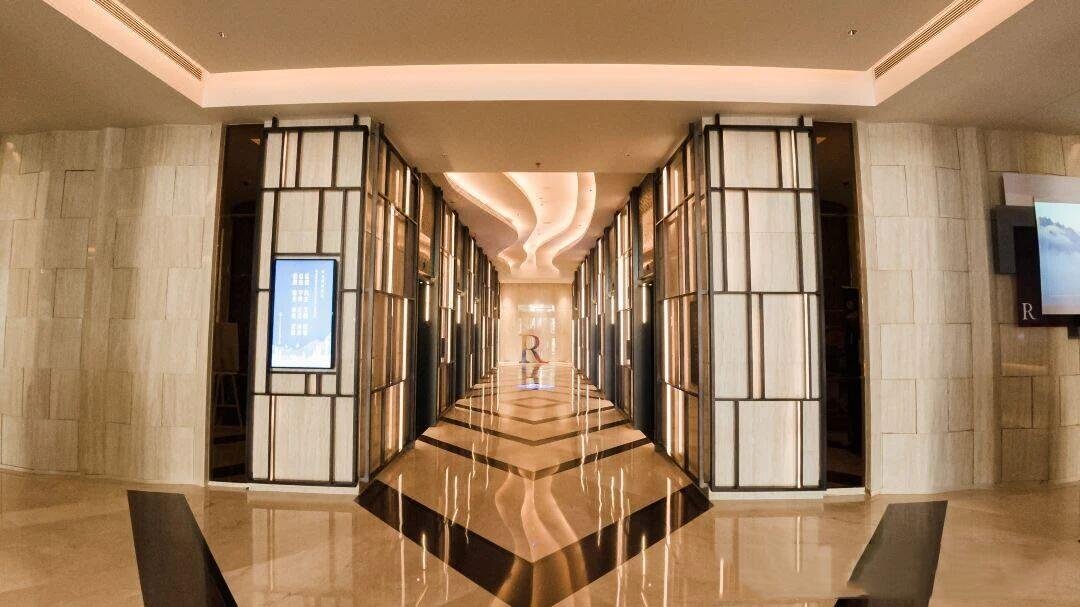 Hotel lobby lounge area with large bronze metal-framed backlit wall panels by XYC Metalworks