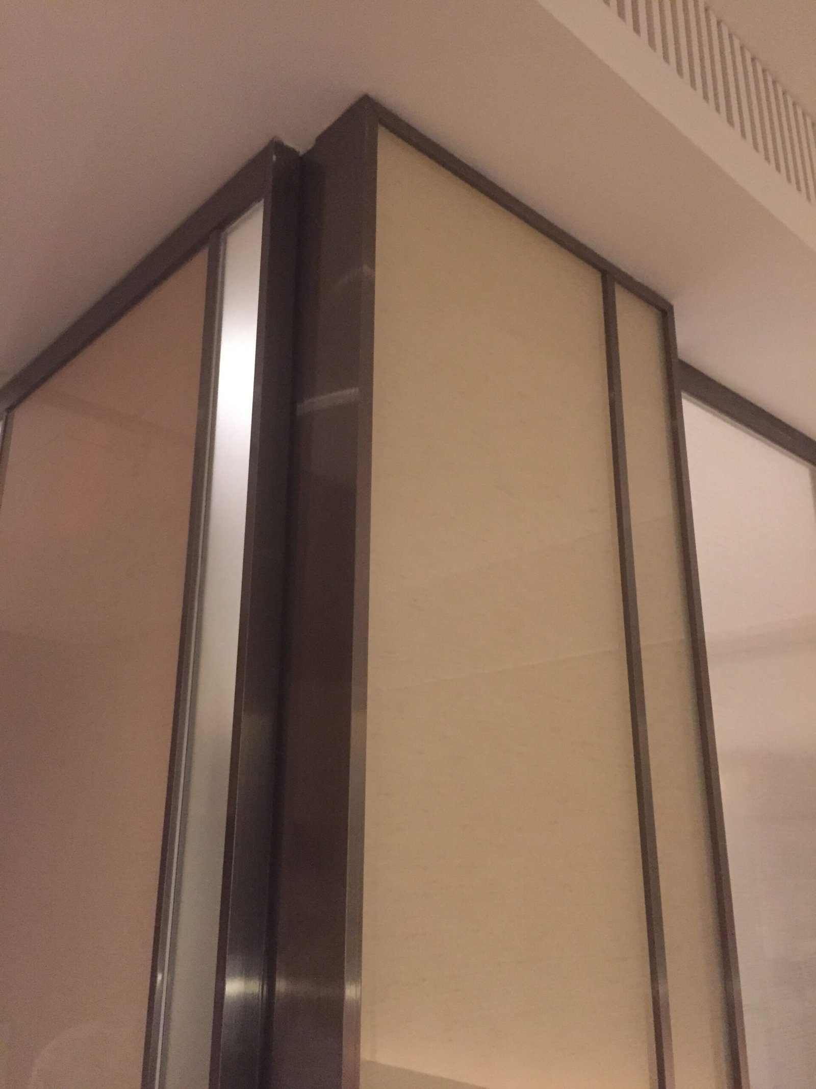 Luxury hotel interior wall paneling featuring stainless steel edge trims and corner decorative pieces.