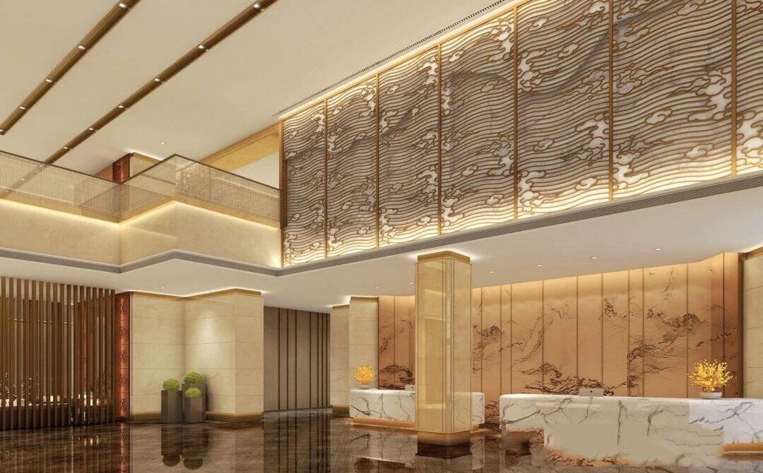 Decorative backlit perforated metal screen feature wall in a luxury hotel lobby, creating an artistic light and shadow effect.