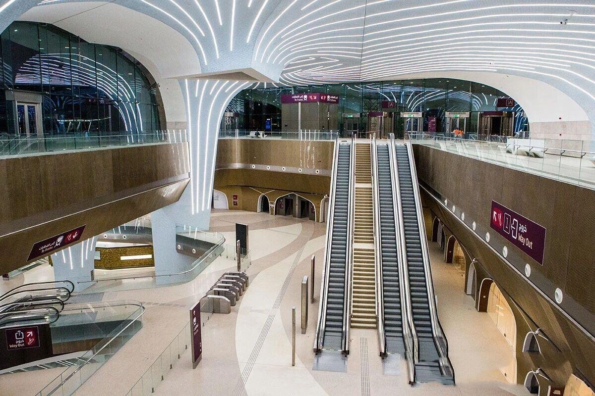 Modern transportation hub interior with expansive curved bronze-finish architectural metal wall cladding for high-traffic durability.