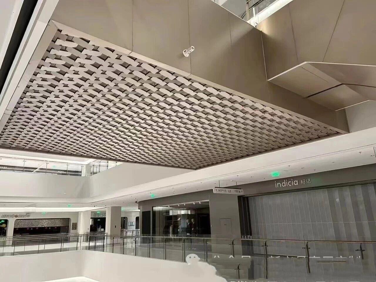 Architectural Metal Ceiling Systems with a 3D woven geometric design for luxury retail and shopping mall interiors.