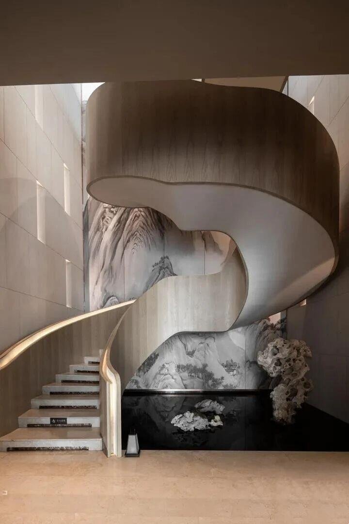 Organic-shaped helical Stainless Steel Staircase and Railing Systems with custom wood-finish metal cladding and integrated handrail lighting.