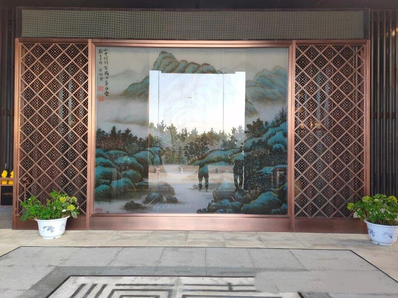 Artistic landscape mural integrated with laser-cut stainless steel sheets in a custom bronze frame for luxury feature walls.