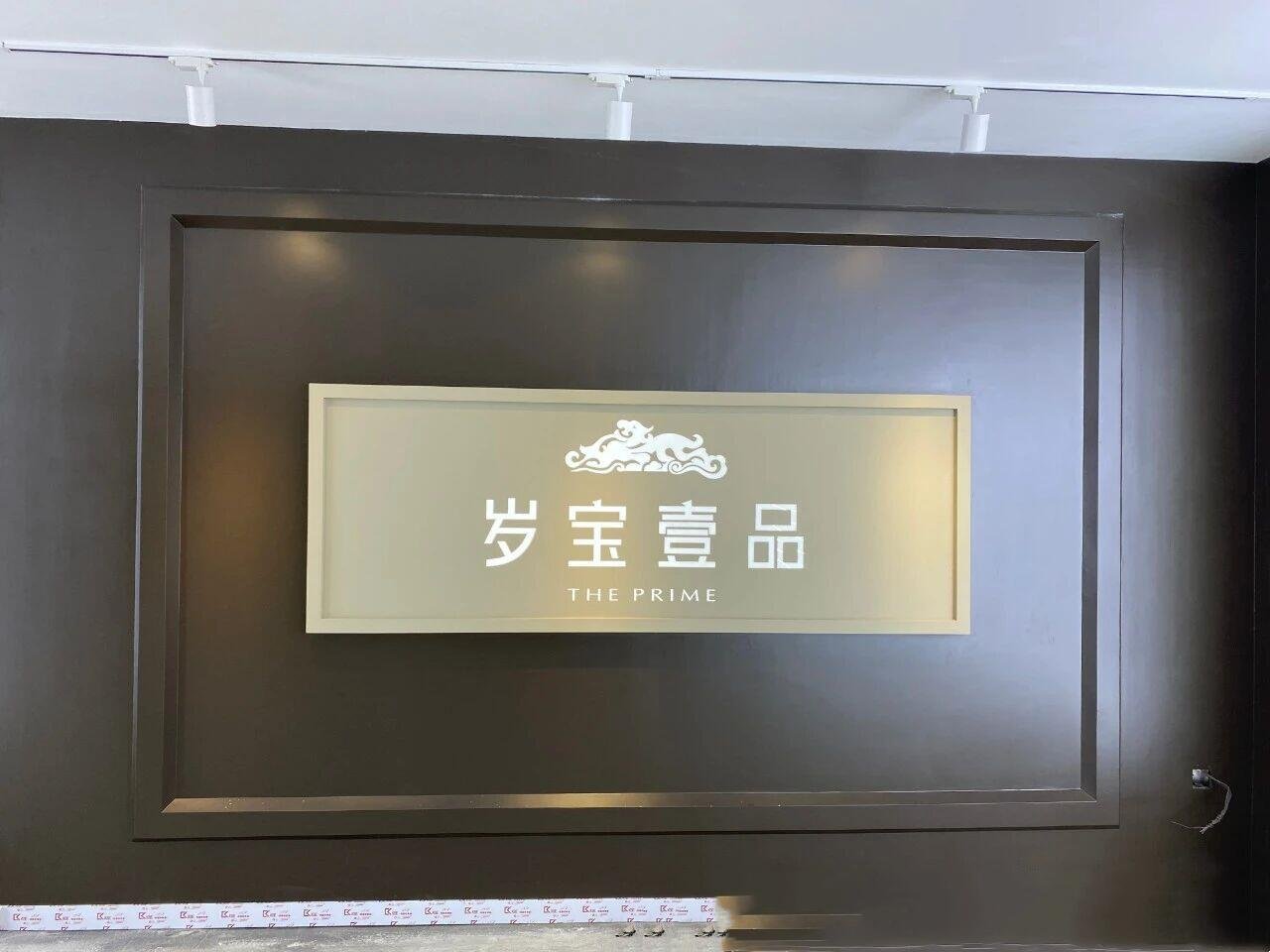 Interior backlit stainless steel logo sign for THE PRIME corporate lobby featuring PVD gold titanium coating and halo-lit effects.