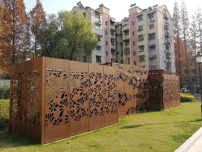 Laser-cut privacy screen and fence illustrating bespoke Corten steel planters and landscape elements.