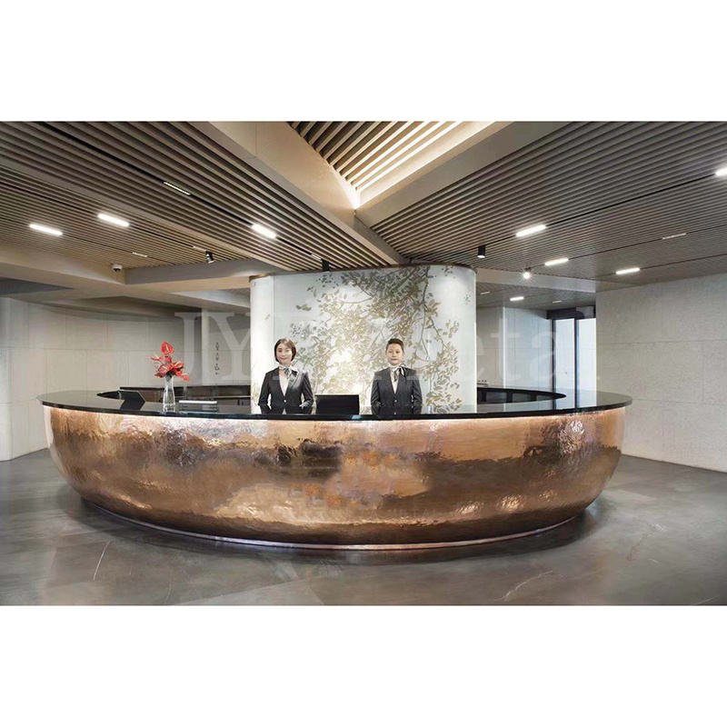Bespoke curved lobby reception desk featuring hand-hammered stainless steel PVD coated bronze color cladding