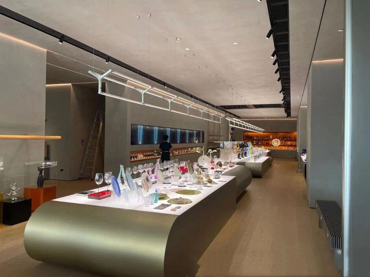 Bespoke PVD gold retail display stand with integrated LED lighting, custom-built for luxury retail showrooms and high-end flagship boutiques.