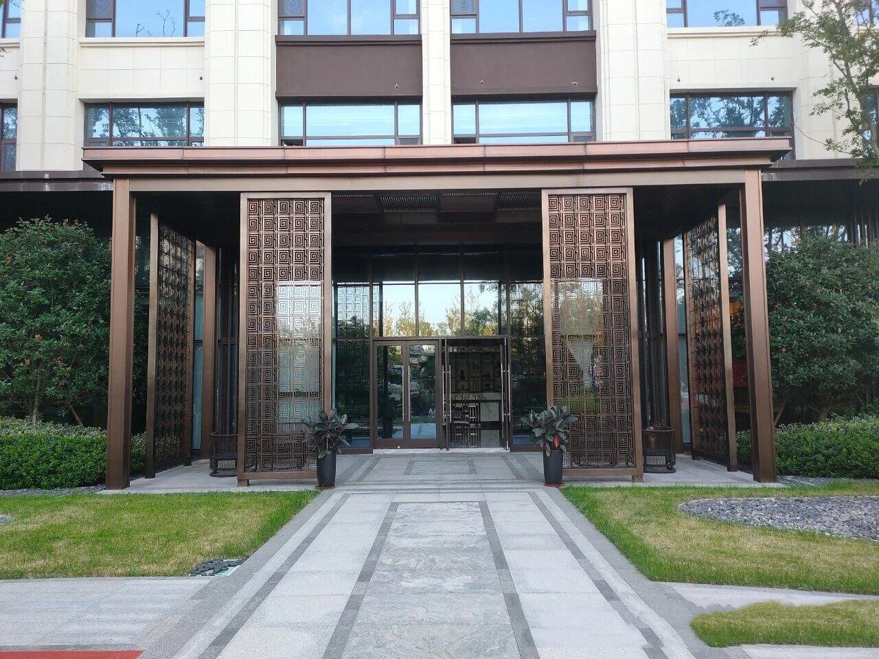 Decorative bronze laser-cut stainless steel sheets used for grand architectural entrance partitions by XYC Metalworks.