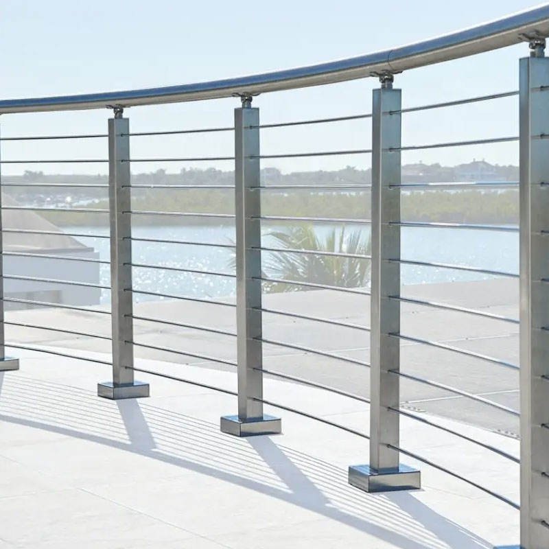 Curved Stainless Steel Railing Systems with square posts and tensioned wire cables for a coastal waterfront terrace.