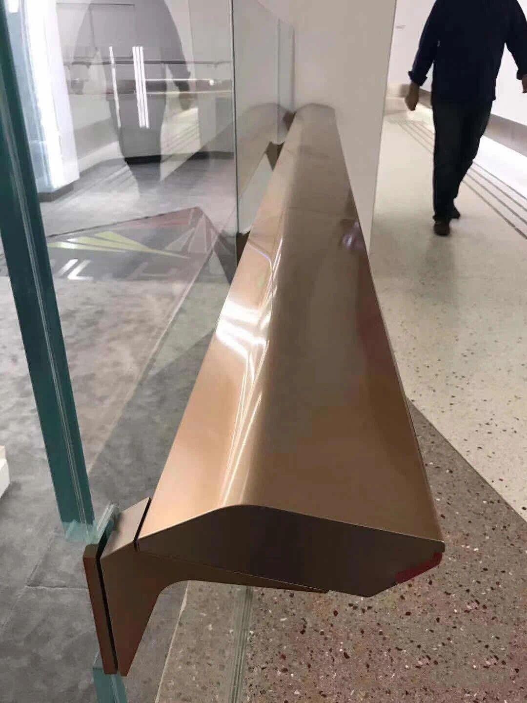 Custom faceted metal capping profile for a glass balustrade in a premium PVD bronze finish.