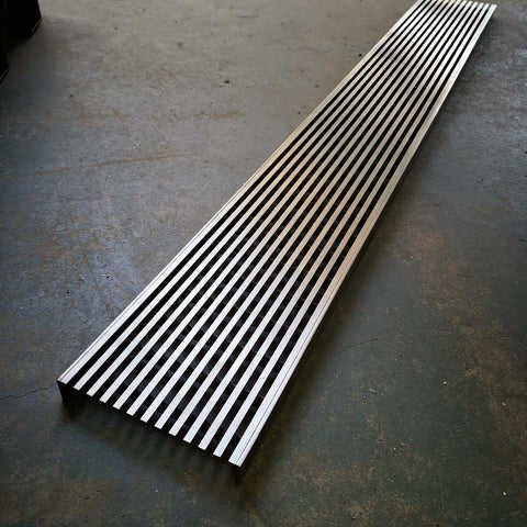 A custom long linear stainless steel grating with a flat bar surface, durable, high-strength, corrosion-resistant for industrial flooring, architectural details, and drainage systems