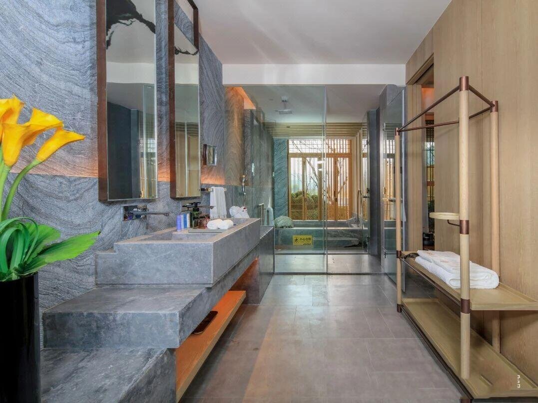 Luxury hotel bathroom featuring a PVD bronze multi-functional shelf from our Bespoke Luggage Racks & Carts collection, showcasing premium Custom Stainless Steel Hotel Furniture and PVD Hospitality Metalwork.