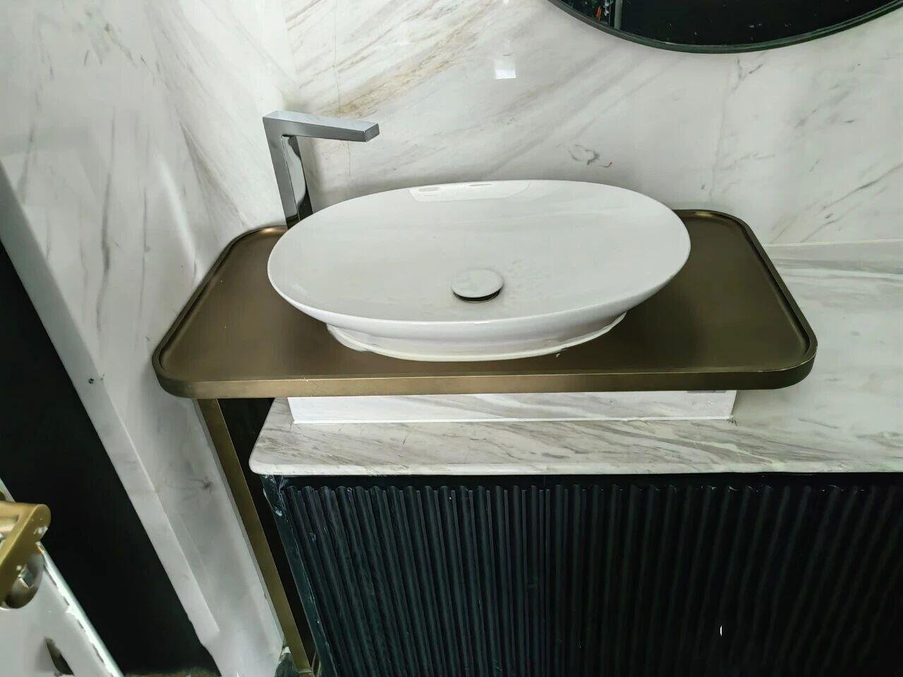 Custom-built PVD bronze stainless steel vanity tray designed to perfectly fit a white vessel sink on a marble countertop.