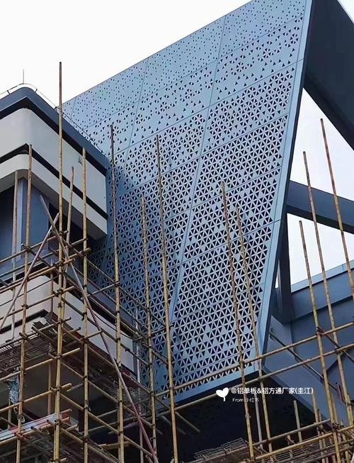 Construction site showcasing the installation of a blue uv resistant metal facade using custom PVDF sheets.