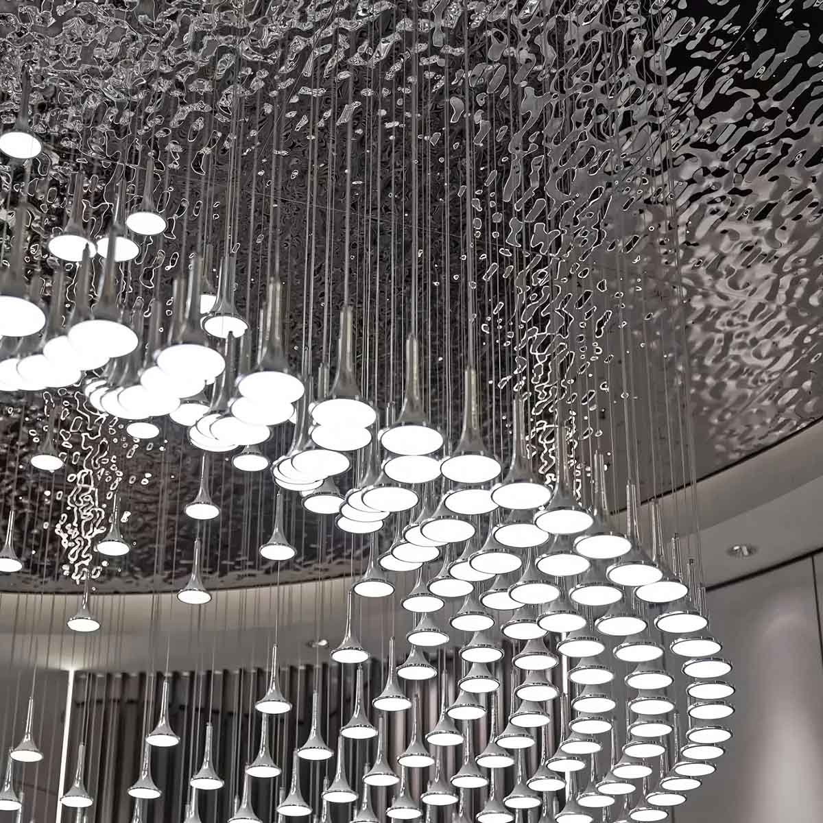 Close-up of decorative lighting installed against a stamped stainless steel ceiling panel with a water ripple texture for a 3D fluid effect.