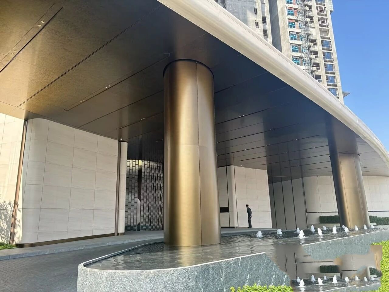 Stainless Steel Column Covers featuring a sandblasted gold finish for hospitality entrance designs and architectural pillar wraps