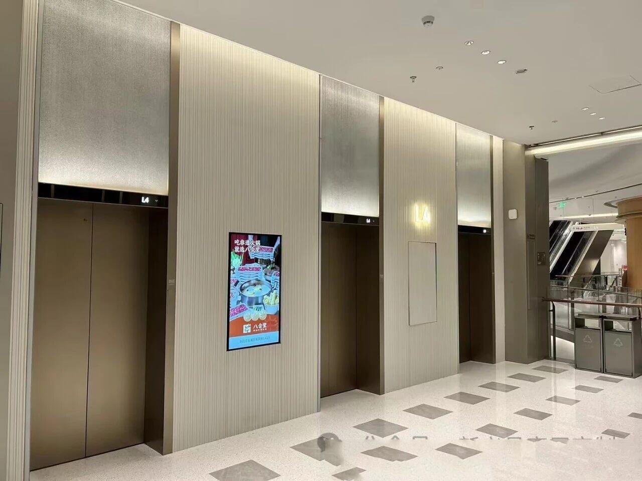 elevator-lobby-textured-stainless-steel-wall-panels-bronze-doors