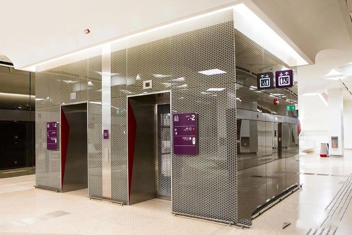 Mirror-polished stainless steel sheets with bespoke etched designs used for expansive interior wall cladding in public spaces.