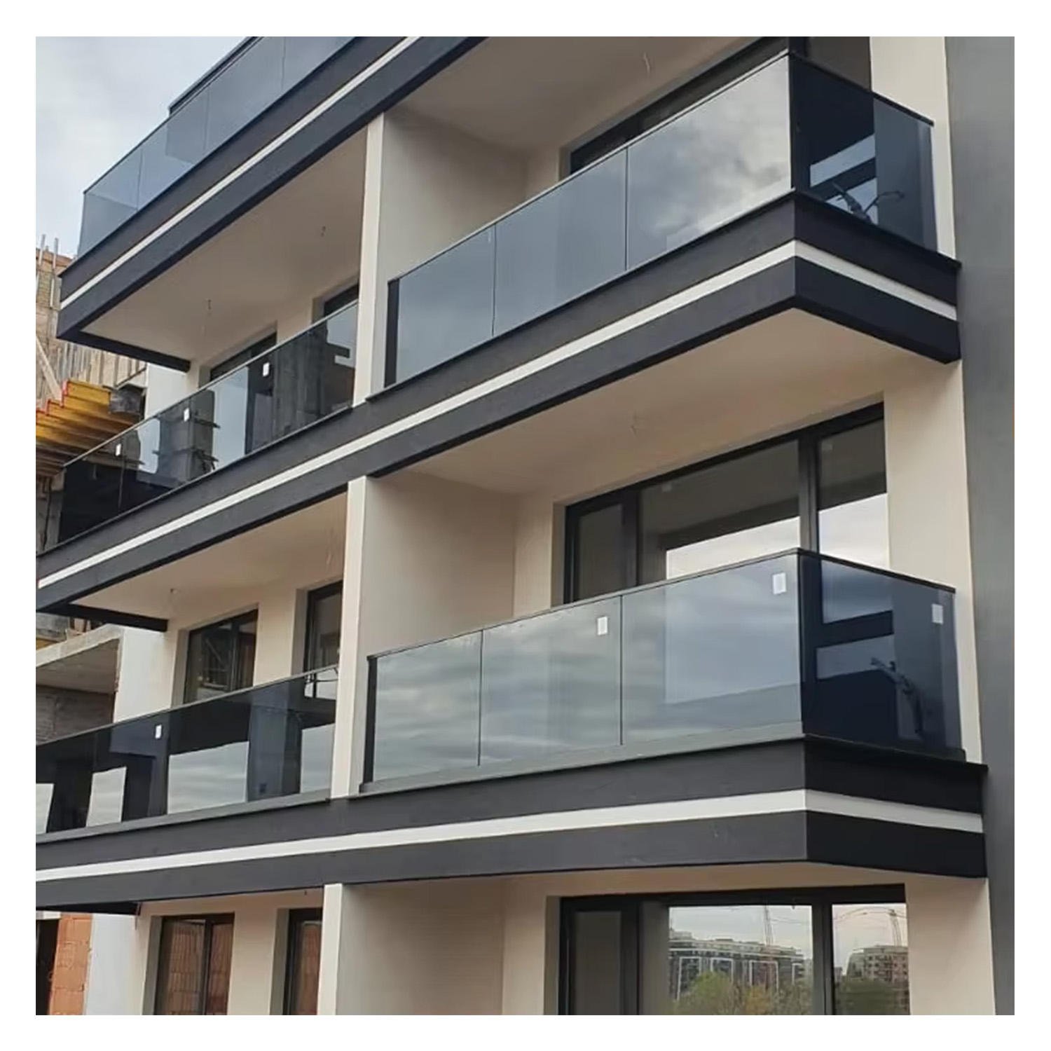 Modern frameless glass balustrade system with black accents on high-rise apartment balconies for unobstructed views.