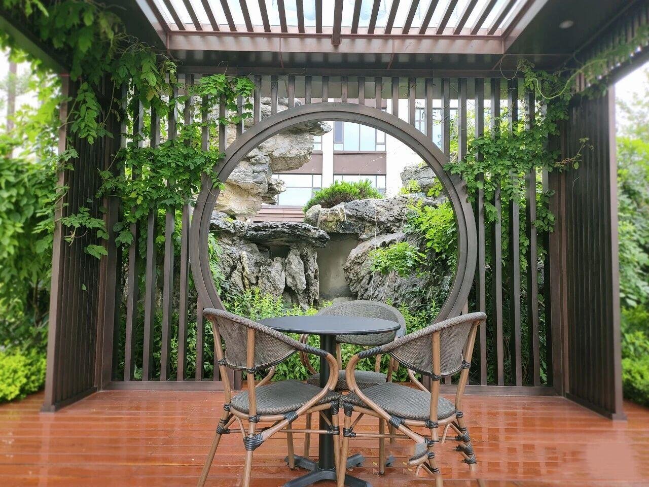 A PVD coated bronze color stainless steel gazebo with louvered roof