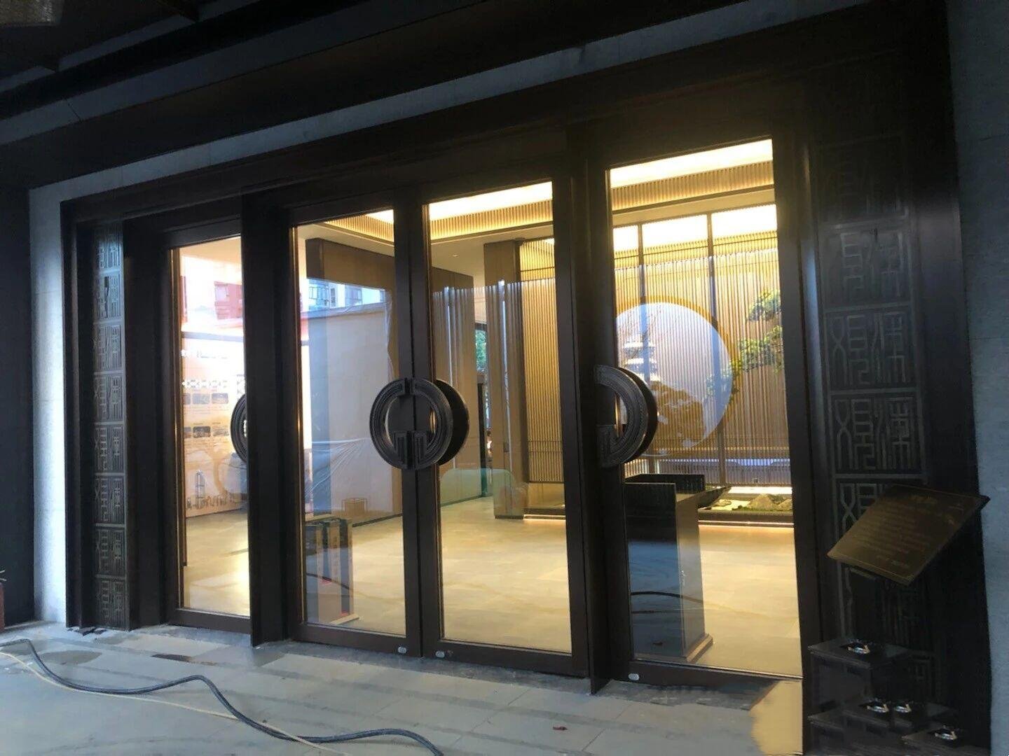 Stainless Steel Interior Doors with PVD dark bronze frames, glass infills, and Custom Pull Handles for office partitions.