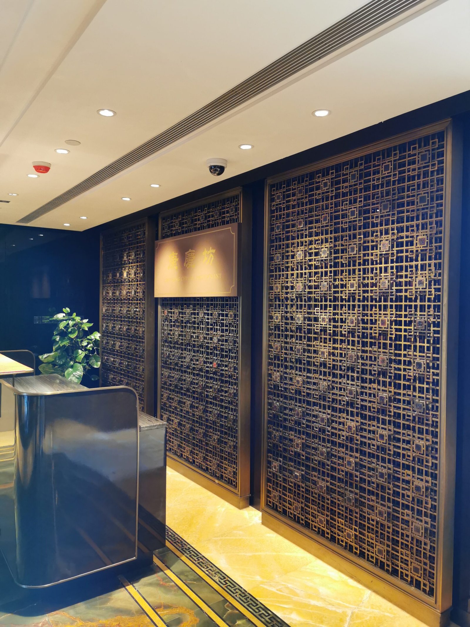 Decorative laser-cut stainless steel sheets with antique bronze finish used as elegant restaurant partition screens by XYC Metalworks.