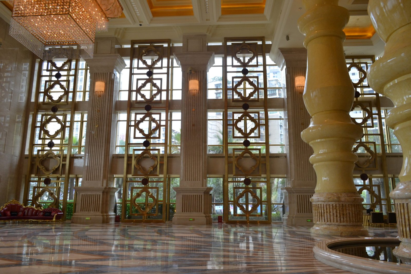 Architectural Metal Partitions in a grand luxury hotel lobby featuring ornate PVD gold decorative floor-to-ceiling screens