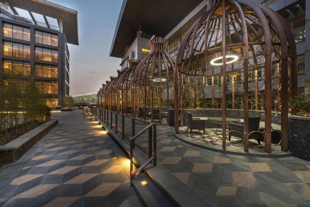 Custom-fabricated metal pavilions and landscape structures for architectural terrace at dusk by XYC Metalworks.