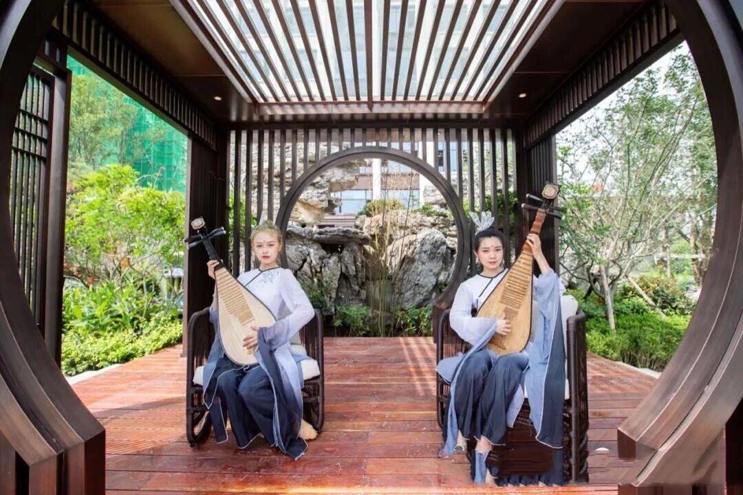 Interior view of a modern Chinese metal teahouse pavilion featuring louvered wall systems and a structural moon gate.