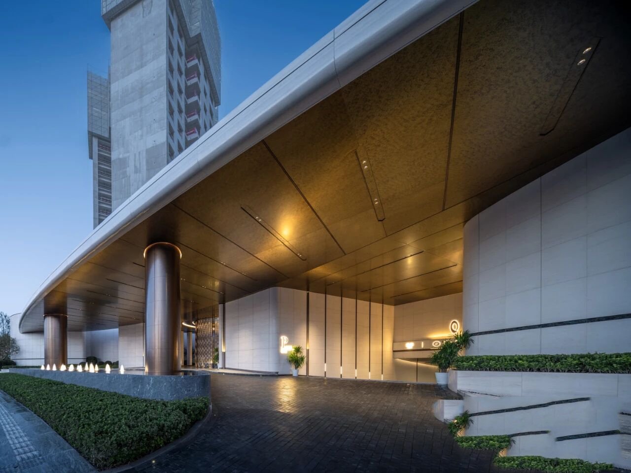 Modern port cochere canopy clad in sandblasted bronze stainless steel panels.