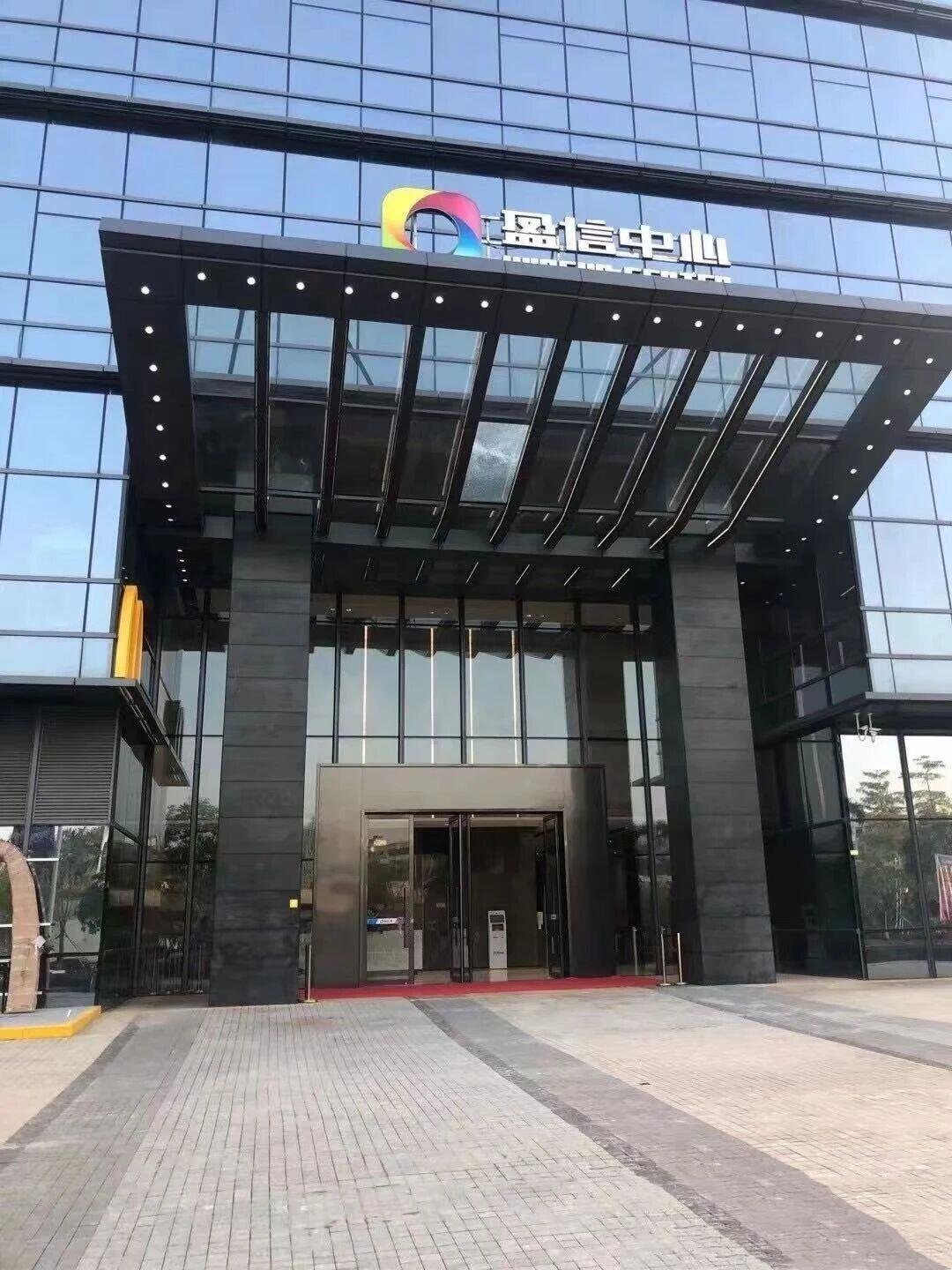 The large metal canopies & custom awnings of a modern office building, constructed from pvd coated black color stainless steel and glass panels.