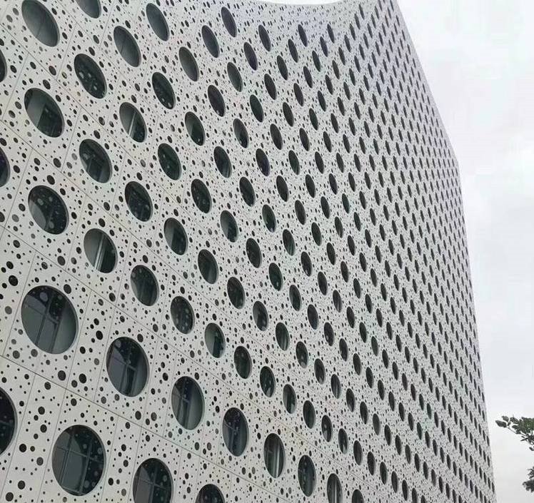 Perforated architectural aluminium cladding with a unique circular pattern for modern building facade design.