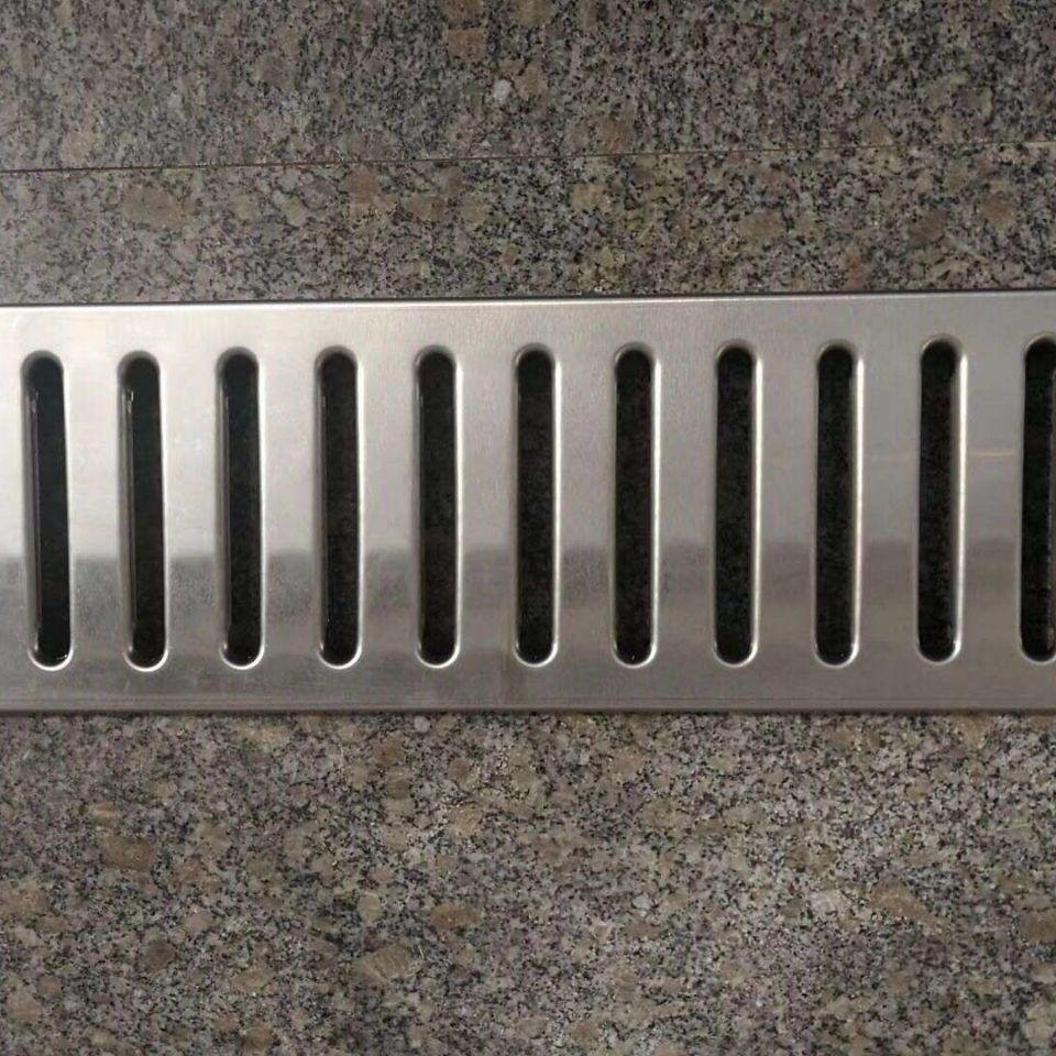 Close-up of custom perforated stainless steel drainage grating for high-end architectural and drainage systems.