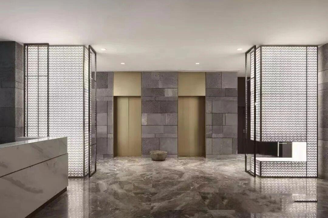 Stainless Steel Elevator Wall Panels in a PVD gold finish featuring decorative architectural screens for a luxury commercial lobby interior