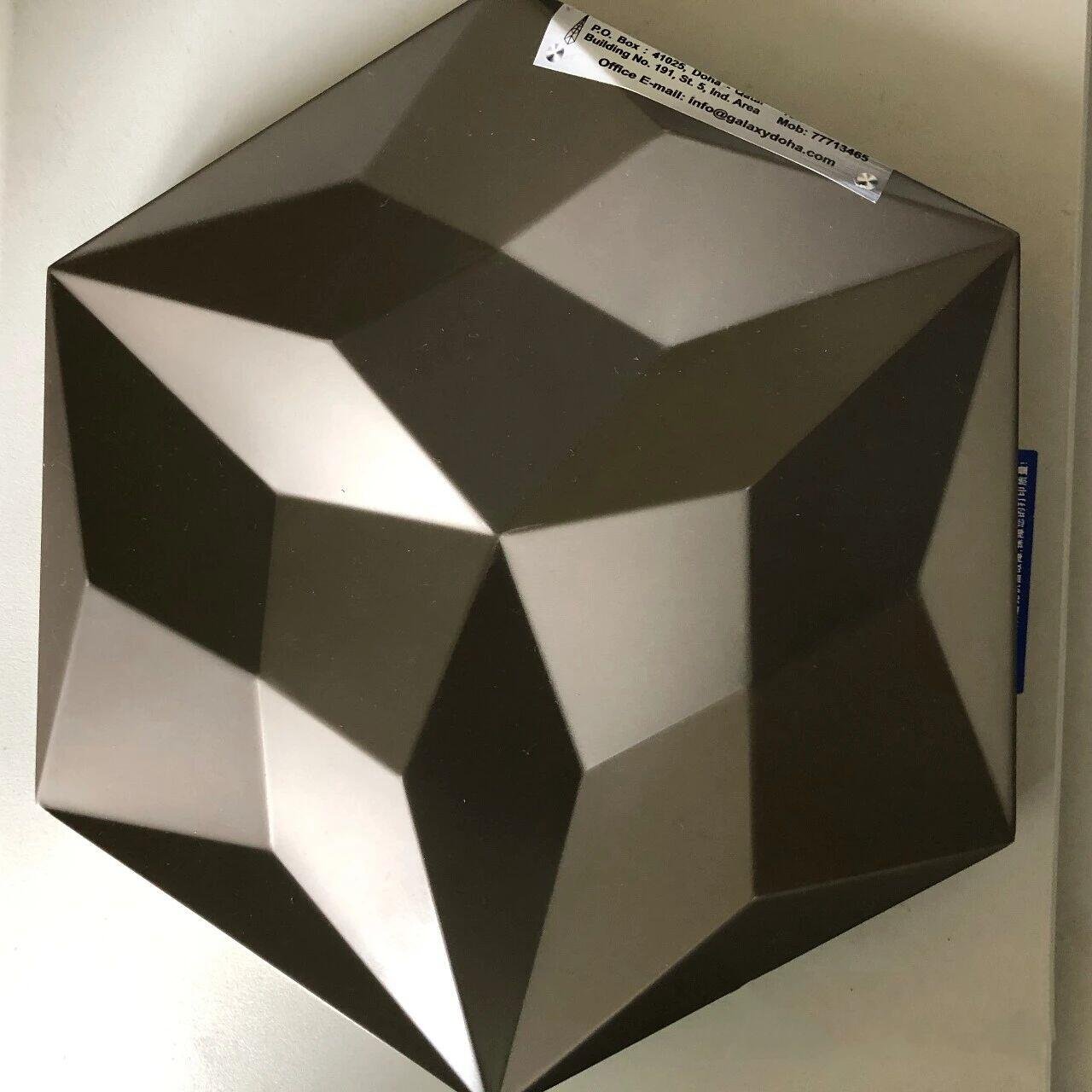 Sandblasted stainless steel sheets fabricated into a dark gray 3D geometric wall tile with a uniform bead-blasted matte finish.