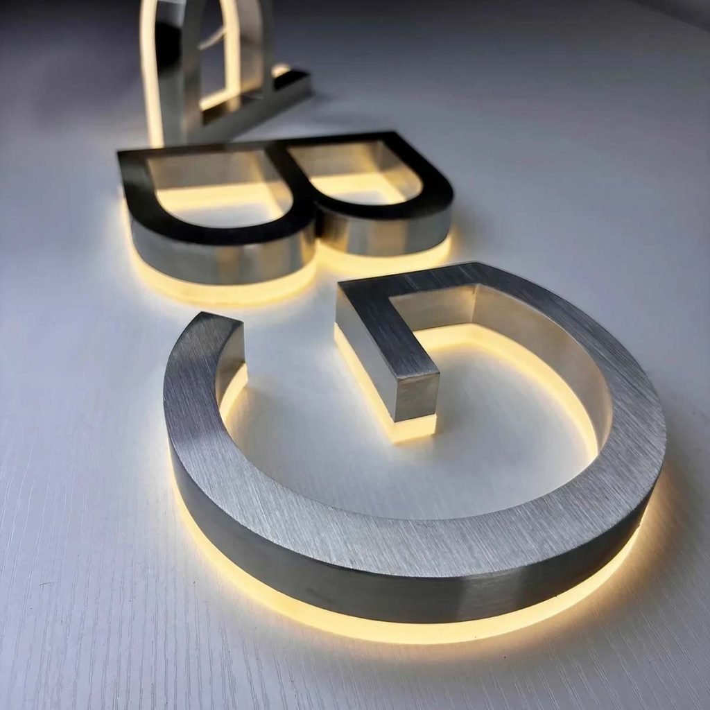 Satin finish stainless steel sheets fabricated into premium backlit signage and branding for a sophisticated corporate identity.