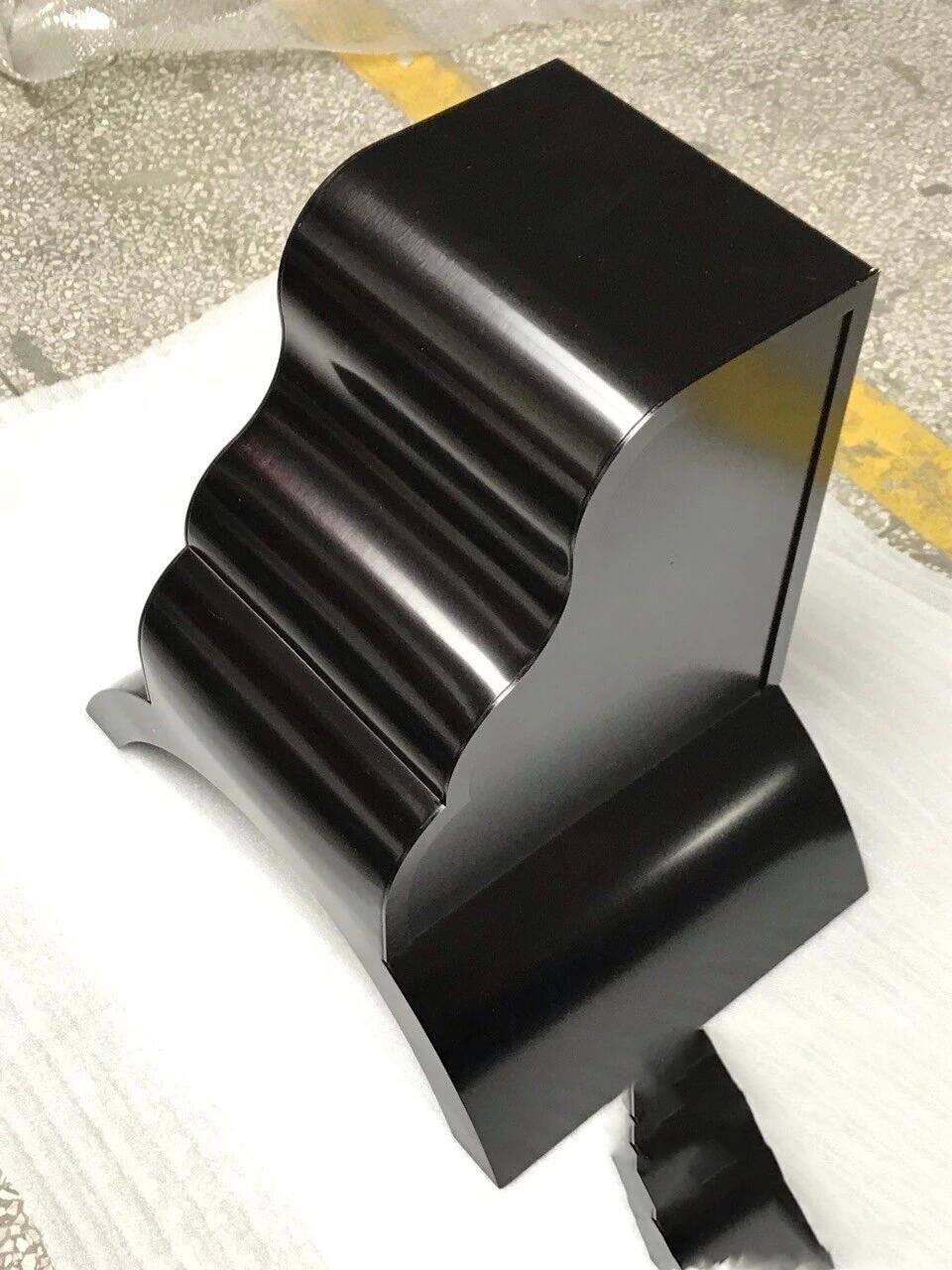 Custom-fabricated PVD black stainless steel beam end cover with a sculptural wave profile for modern architectural decor.