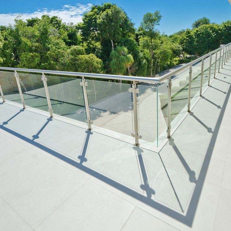 Stainless Steel Railing Systems featuring round posts and glass balustrades for a modern architectural rooftop terrace