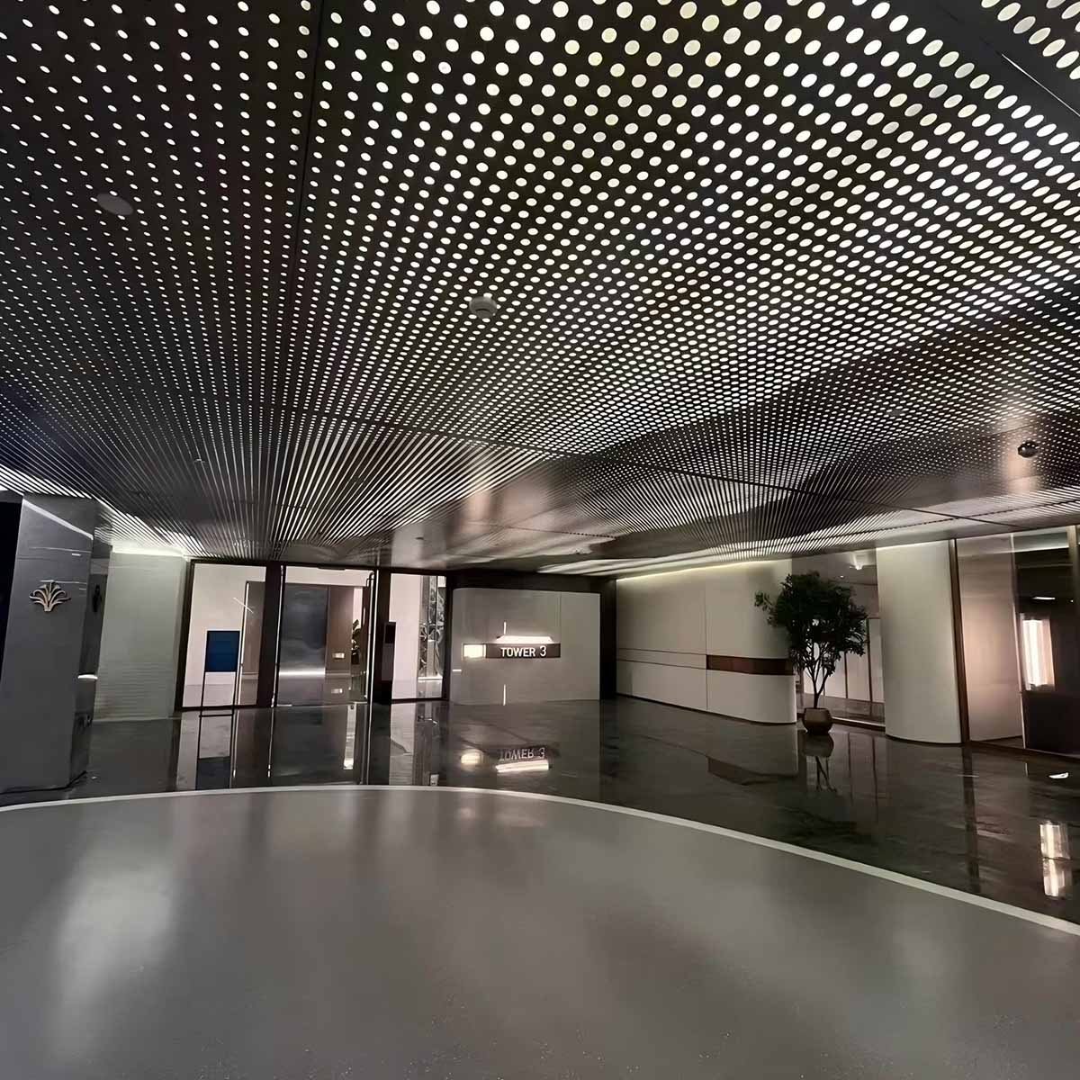 Luxury lobby featuring perforated stainless steel sheets as an acoustic ceiling with a starlight lighting effect by XYC Metalworks.