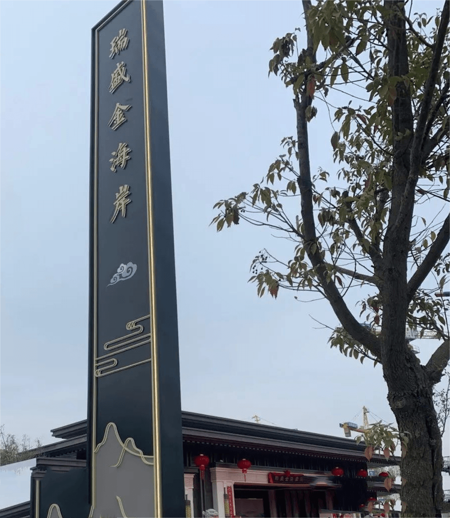 Large-scale vertical pylon sign featuring gold-finished Custom Fabricated Letters, exemplifying our engineering expertise in Architectural Metal Signage and Stainless Steel & Brass Signs.