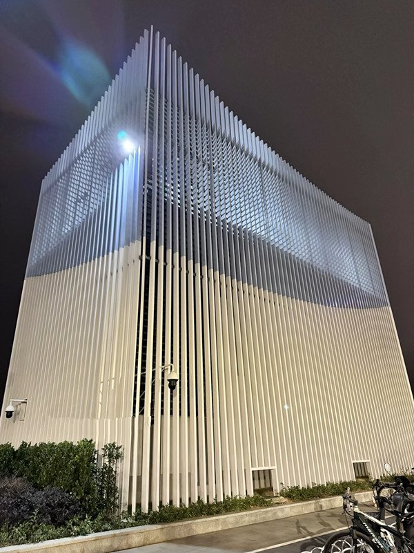 Grand architectural facade featuring vertical silver Anodized Aluminium Sheet Metal fins for aesthetic depth and shading.