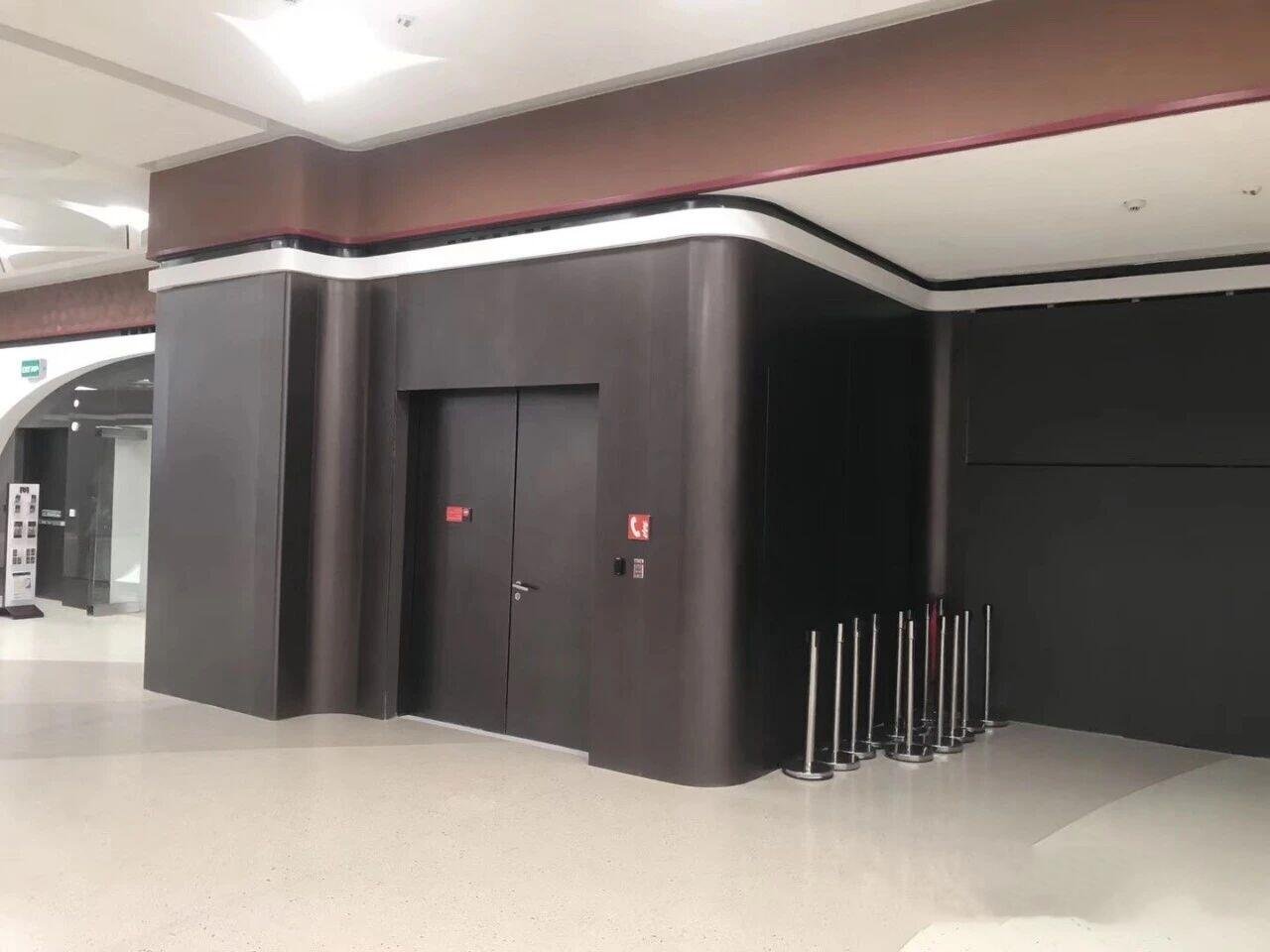 Vibration finish stainless steel sheets in a sleek black matte finish used for luxury commercial hallway wall cladding and integrated door systems by XYC Metalworks.