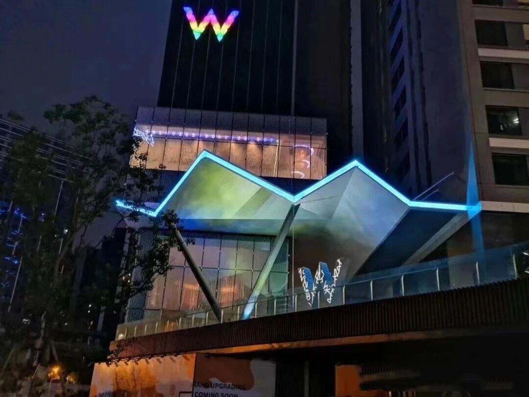 Geometric architectural metal canopy featuring angular stainless steel panels and integrated LED lighting for W hotel.