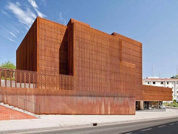 Weather-resistant expanded metal mesh with a Corten-look finish for durable and aesthetic building exterior cladding.