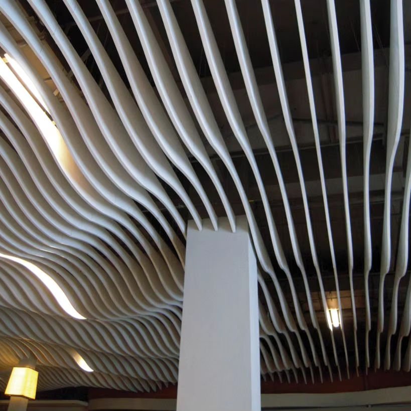 Architectural Metal Ceiling Systems showcasing a white wave profile baffle design for artistic and modern ceiling finishes.