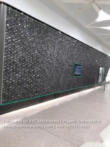 Large-scale 3D geometric feature wall in dark metallic finish, a signature architectural metal installation for Doha Metro.