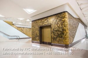 Luxury 3D gold metal wall cladding installed at a Doha Metro elevator lobby, showcasing XYC METALWORKS' premium fabrication.